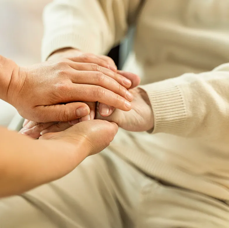 Astar Homecare carer holding hands with an elderly woman, offering personal care and compassionate support at home.